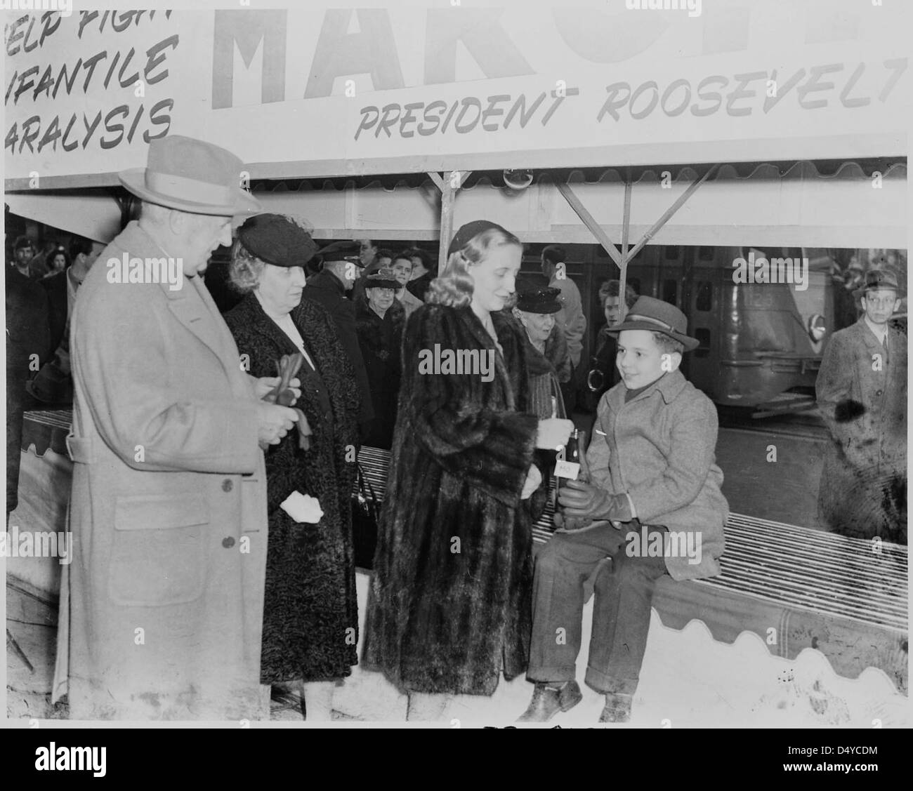 Photographie de Margaret Truman en train de déposer une pièce dans une bouteille tenue par un jeune garçon dans le cadre d'une apparition publique au nom de la Marche des Dimes... Banque D'Images