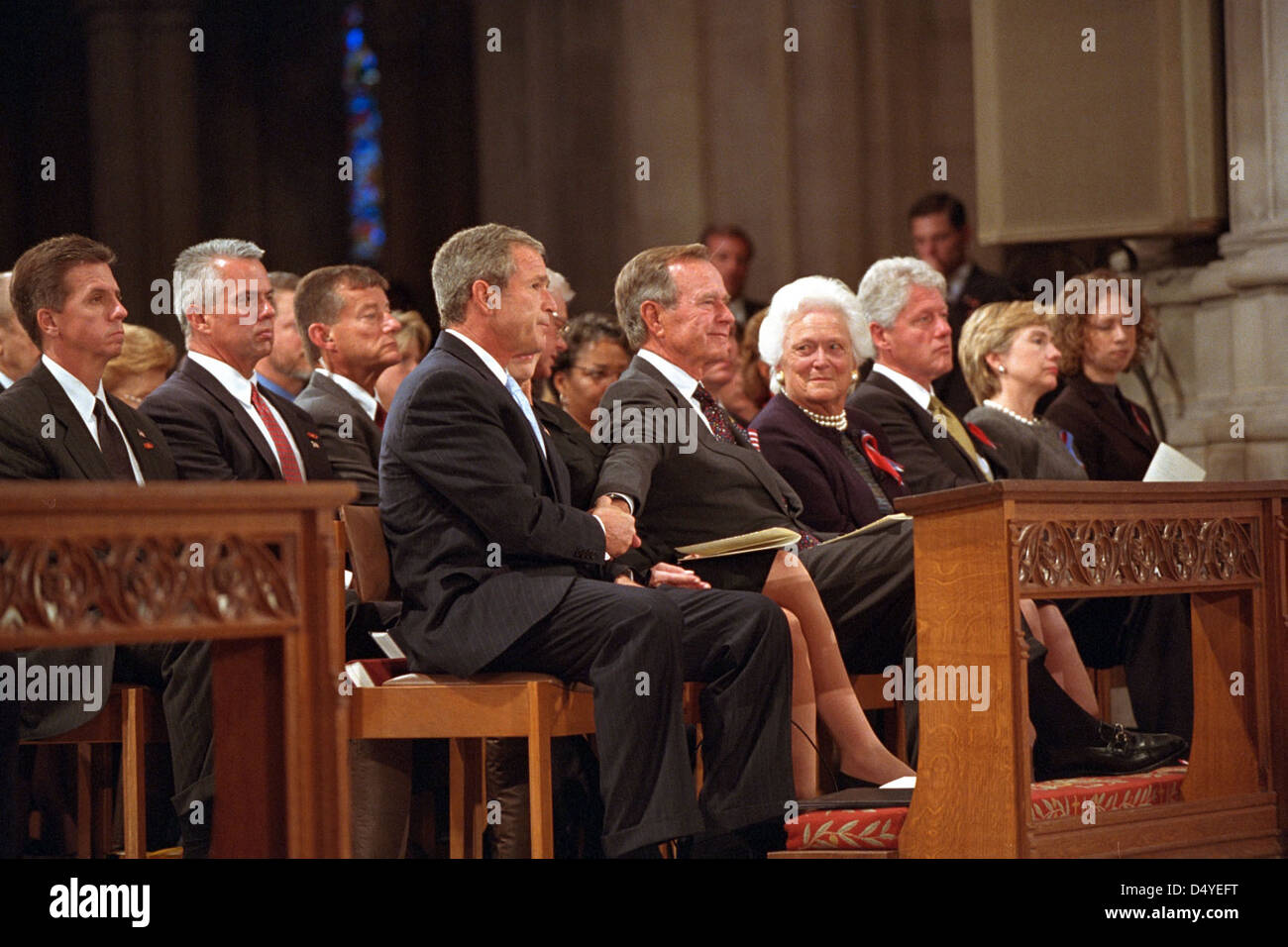 Le Président George W. Bush saisit la main de son père, l'ancien Président George H. W. Bush, vendredi 14 septembre 2001, après avoir parlé au service de la Journée nationale de prière et de souvenir de l'Amérique à la Cathédrale nationale de Washington, D.C., assis avec le Président de gauche à Washington, sont : Mme Barbara Bush, l'ancien président Bill Clinton, la sénatrice Hillary Rodham Clinton et Chelsea Clinton. Photo d'Eric Draper, avec l'aimable autorisation de la bibliothèque présidentielle George W. Bush Banque D'Images