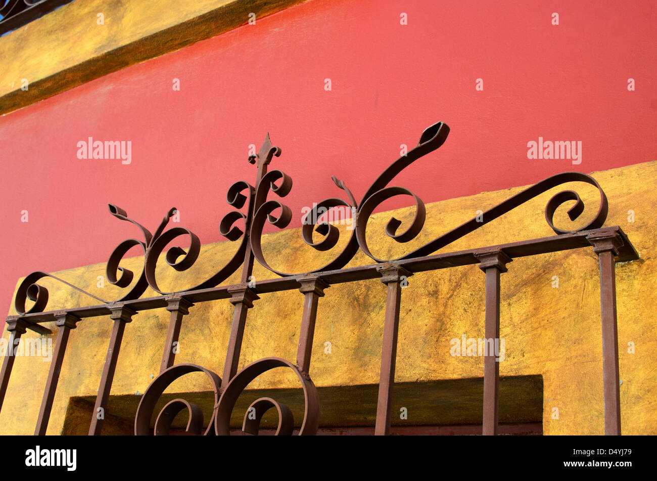 Une grille de sécurité en fer forgé à Oaxaca, Mexique, sur un mur de plâtre jaune et orange. Banque D'Images