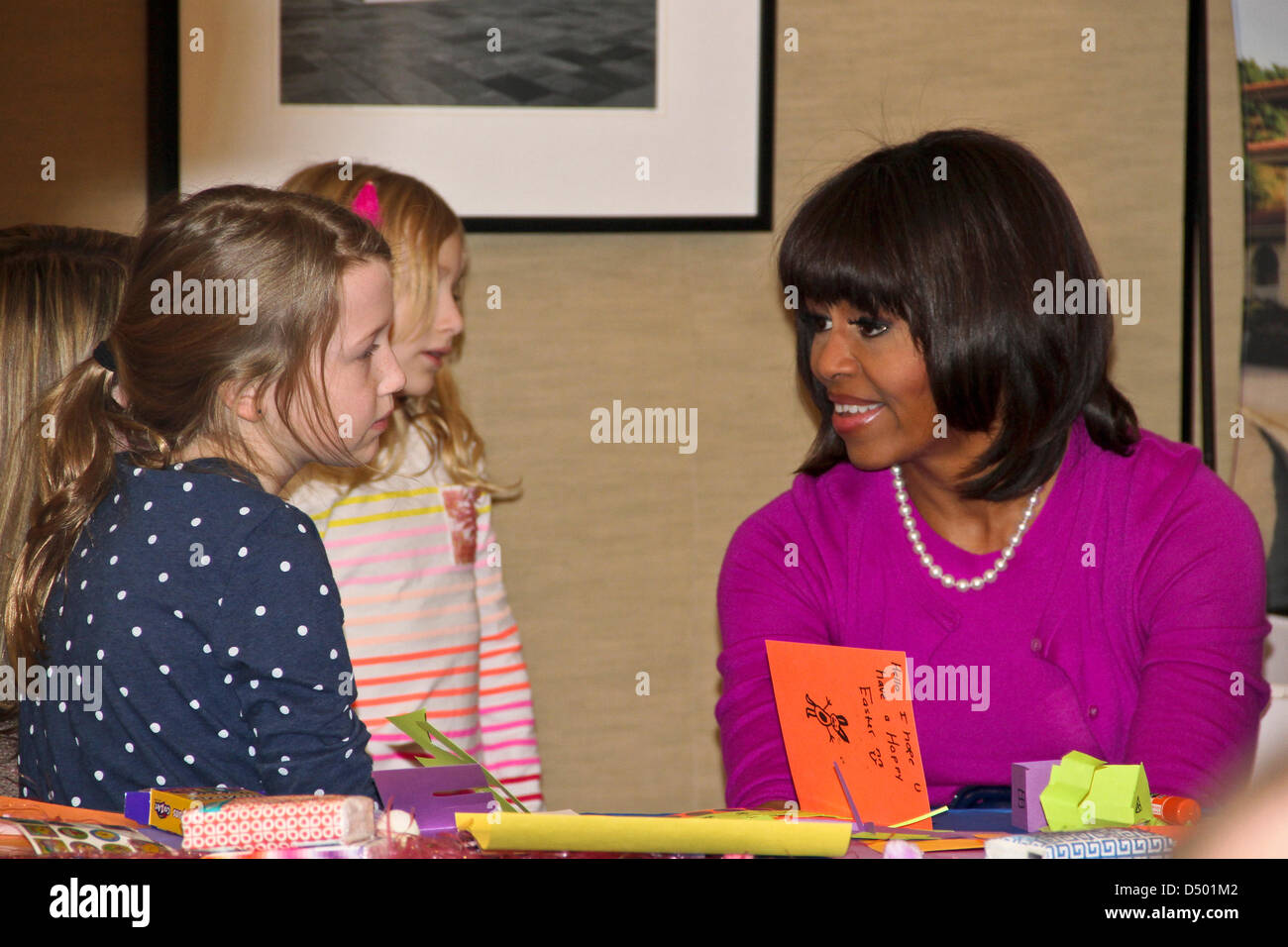 Première Dame Michelle Obama s'entretient avec Deryn Allen, gauche, et sa jeune sœur, Ryann Allen, lors d'une visite de Pâques avec des membres des familles des militaires à Fisher House n°4 sur le campus de l'Armée nationale Walter Reed Medical Center le 20 mars 2013 à Bethesda, MD. La Première Dame a invité les enfants à la Maison blanche aux Œufs de Pâques dans le cadre de son initiative de réunir les forces nationales pour appuyer les militaires et leurs familles. Banque D'Images