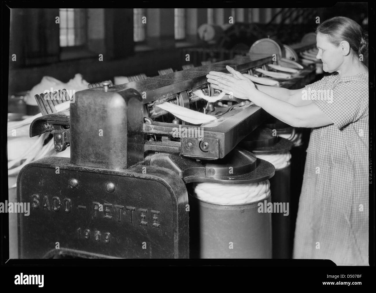 En avril 1937, Lewis Hine a capturé une photo en gros plan d'un cadre de dessin de coton à Pacific Mills, montrant le coton en cours de traitement dans la machine. Cette image met en valeur les pratiques industrielles de l’époque. Banque D'Images