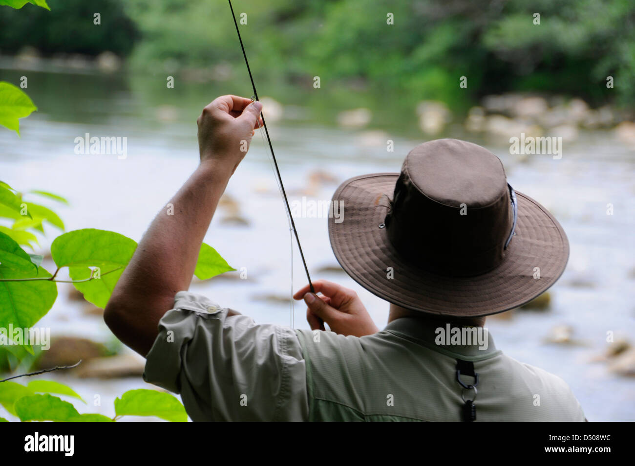 Un homme pêche à la mouche dans une rivière Banque D'Images