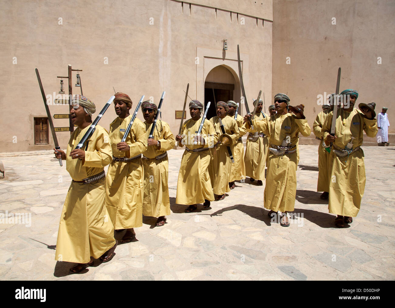 Une troupe de danse traditionnelle épée d'effectuer à l'extérieur du fort de Nizwa en Oman Banque D'Images