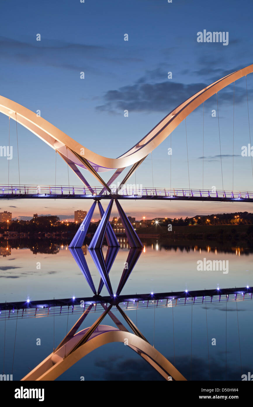 Le pont de l'infini, Stockton-on-Tees, reflétée dans le fleuve Tees au coucher du soleil. Banque D'Images