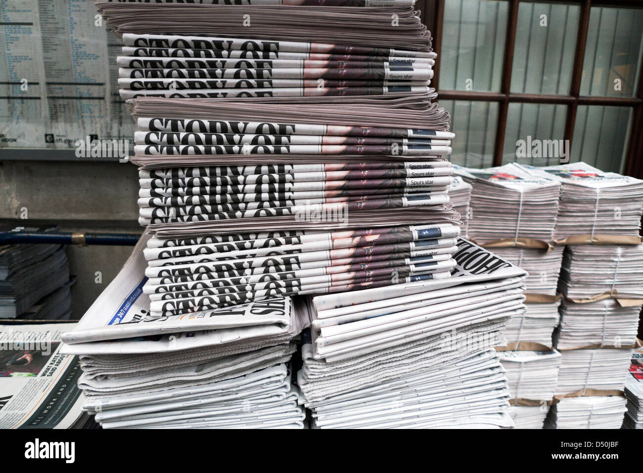 Pile de journaux sur un kiosque à journaux devant une station de métro Dans Central City of London, Angleterre, Royaume-Uni KATHY DEWITT Banque D'Images