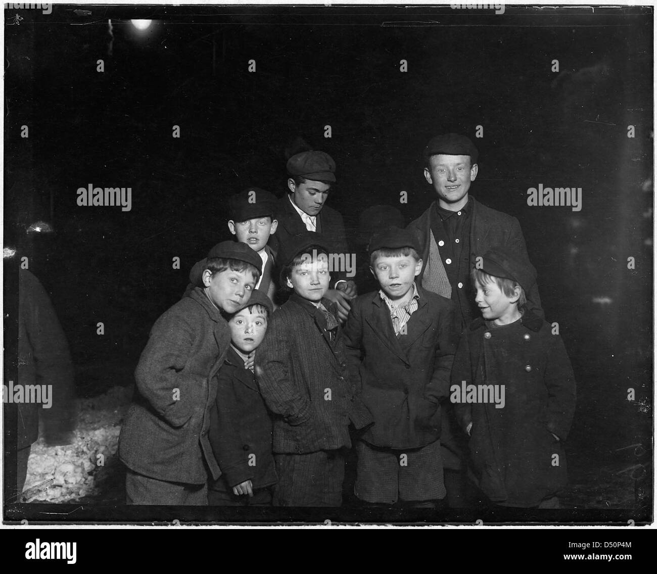En février 1910, un groupe de jeunes est vu dans les rues de Troy, New York, tard dans la nuit, illustrant les défis du travail des enfants et de la vie de rue pendant cette période. Banque D'Images