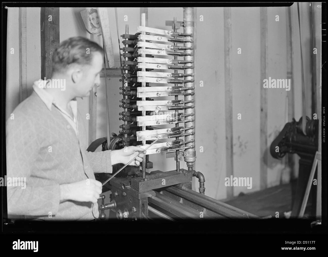 En mars 1937, des ouvriers de Millville, New Jersey, sont vus dessiner du verre à partir d'un tube. Cette image de Lewis Hine documente le travail industriel pendant la Grande dépression. Banque D'Images