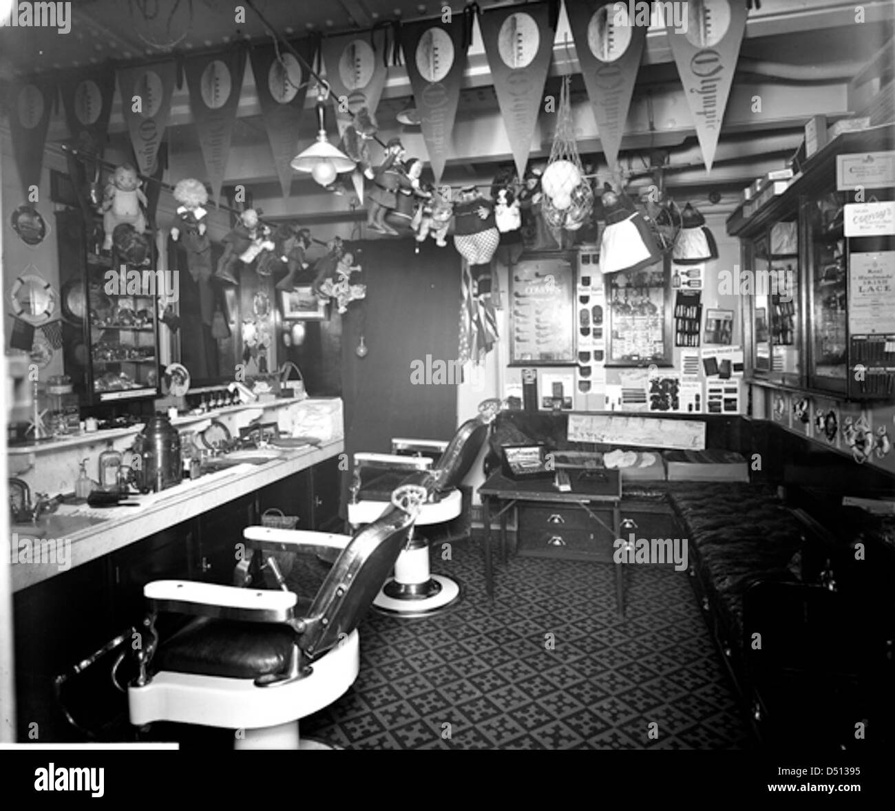 Cette image montre le salon de coiffure de deuxième classe à bord du RMS *Olympic*, l'un des paquebots emblématiques de la White Star Line. Le navire était une merveille de l'ingénierie et du luxe du début du XXe siècle, avec des espaces comme ce salon de coiffure offrant des services aux passagers. Banque D'Images