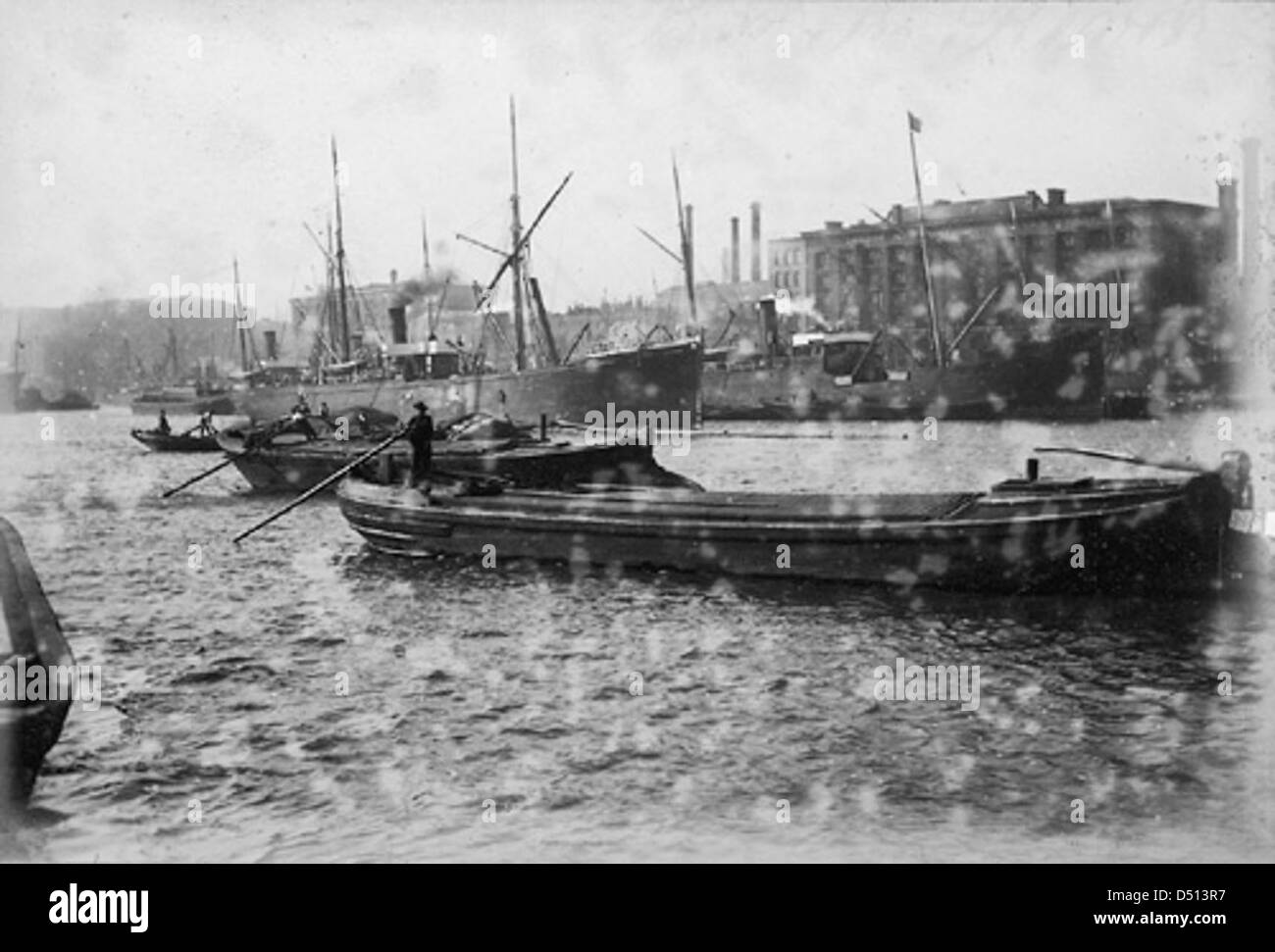 Une photographie historique de briquets et de bateaux à vapeur opérant dans la piscine de Londres, reflétant l'activité maritime animée de la ville au cours du XIXe et du début du XXe siècle. Banque D'Images