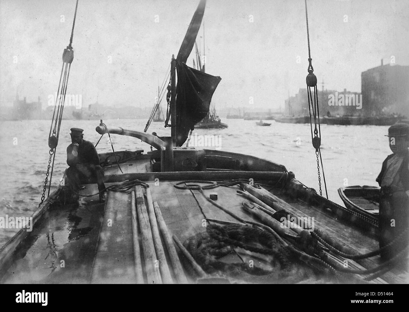 Cette image capture la vie à bord d'une barge à voile sur la Tamise. La photographie met en valeur la culture maritime britannique traditionnelle et l’importance du transport fluvial dans l’histoire de Londres. Banque D'Images