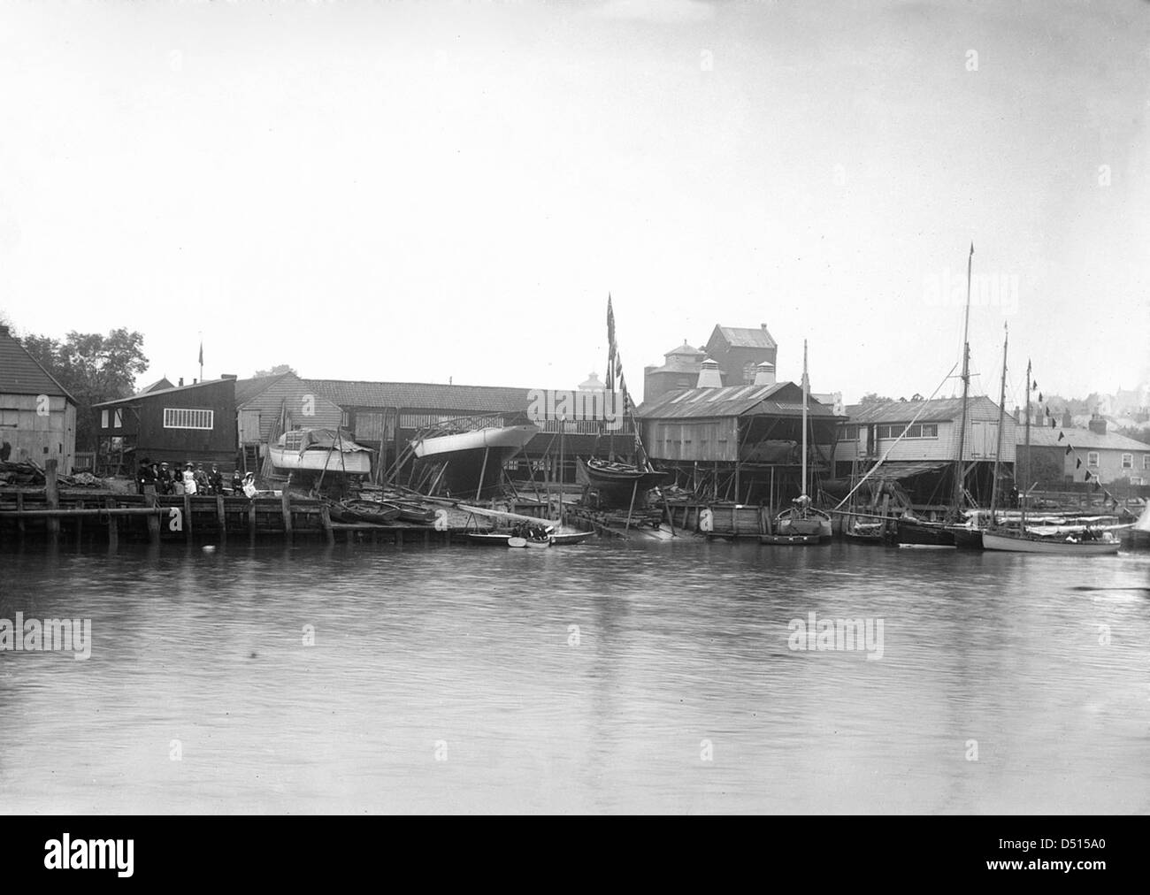 Cette photographie montre la façade de la rivière du chantier naval Harris, prise du côté Wivenhoe de la rivière Colne. Le chantier naval a une longue histoire dans la construction navale et l'industrie maritime. Banque D'Images