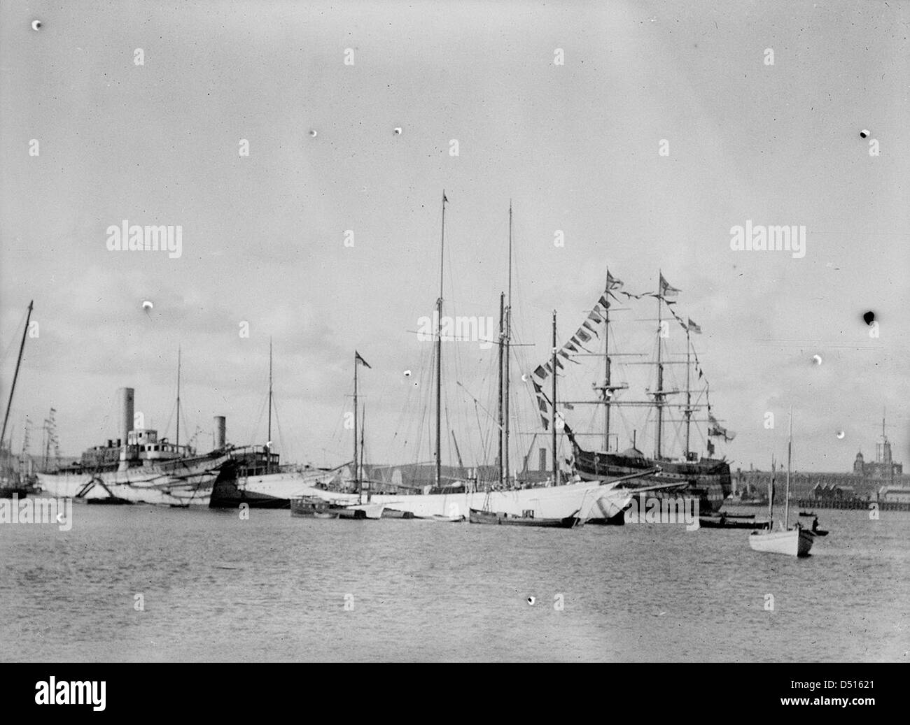 Cette image offre une vue depuis Gosport à travers le port de Portsmouth, avec la tour sémaphore de Portsmouth Dockyard et l'emblématique HMS Victory. Le navire historique est une exposition clé au National maritime Museum, représentant l'histoire navale britannique. Banque D'Images
