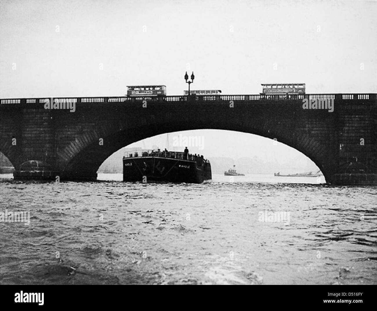 Le SS « Wandle », un bateau à vapeur, est capturé en passant sous le London Bridge, l'un des monuments les plus emblématiques de la ville. La photographie du National maritime Museum souligne l'importance historique des voies navigables et du commerce maritime de Londres. Banque D'Images