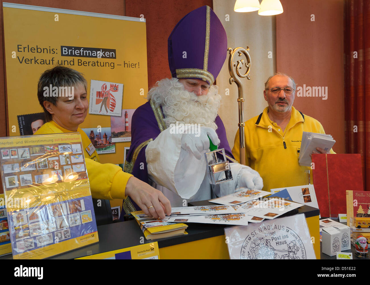 Santa Rudolf Lange (M) stamps lettres au père au cours de l'ouverture du bureau de poste de noël, Allemagne, 5 décembre 2010. Il obtient le soutien de Dagmar Haever (L) et Heinz Grimm. Les lettres sont acceptées jusqu'à la veille de Noël. Ils sont estampillés avec le cachet de la santa et envoyé. 15 000 lettres d'enfants doivent être envoyés et répond. Le bureau de poste de noël à St N Banque D'Images