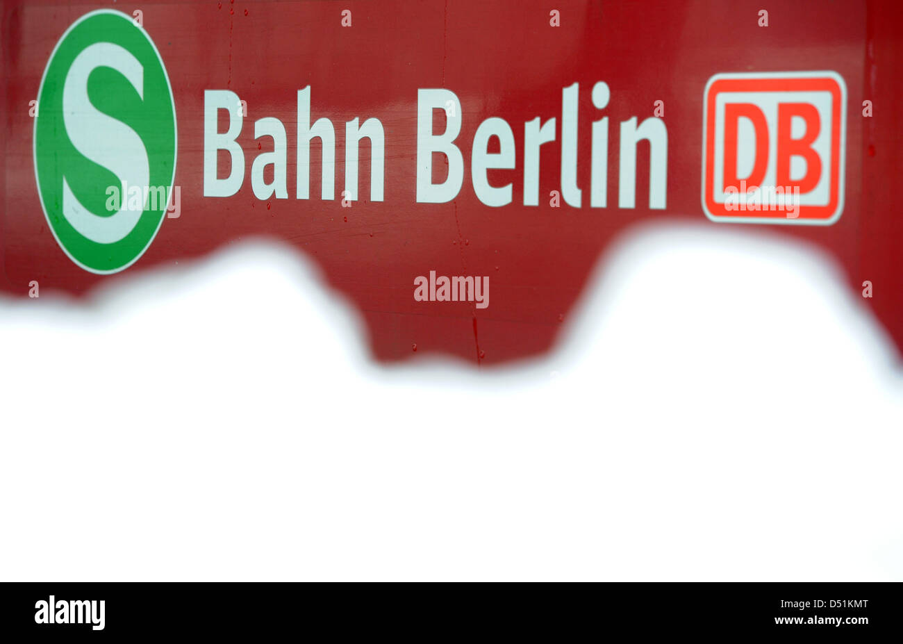 Une montagne de neige accumulée se trouve en face du logo de la S-Bahn les services de trains de banlieue géré par la Deutsche Bahn à l'arrêt de S-Bahn Ostkreuz à Berlin, Allemagne, 8 décembre 2010. Chutes de neige et des températures sous zéro dans les derniers jours a conduit à plusieurs reprises pour les retards et les annulations de train de banlieue (S-Bahn) de services. Photo : Tobias Kleinschmidt Banque D'Images