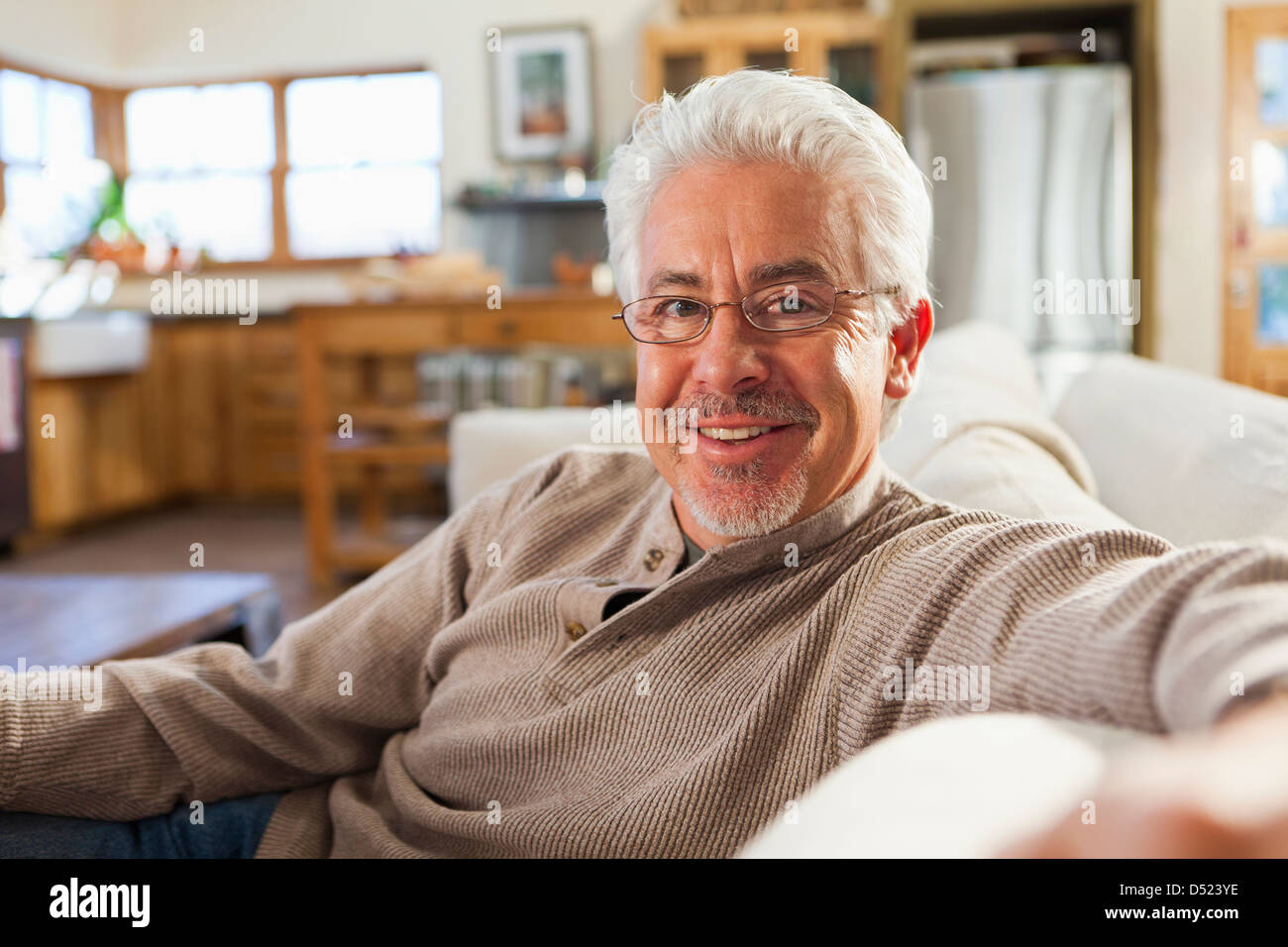 Hispanic man sitting on sofa in living room Banque D'Images