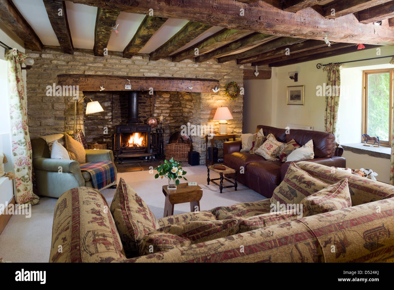 Un chalet confortable salle de séjour avec un poêle à des murs en pierre et poutres au plafond. Banque D'Images