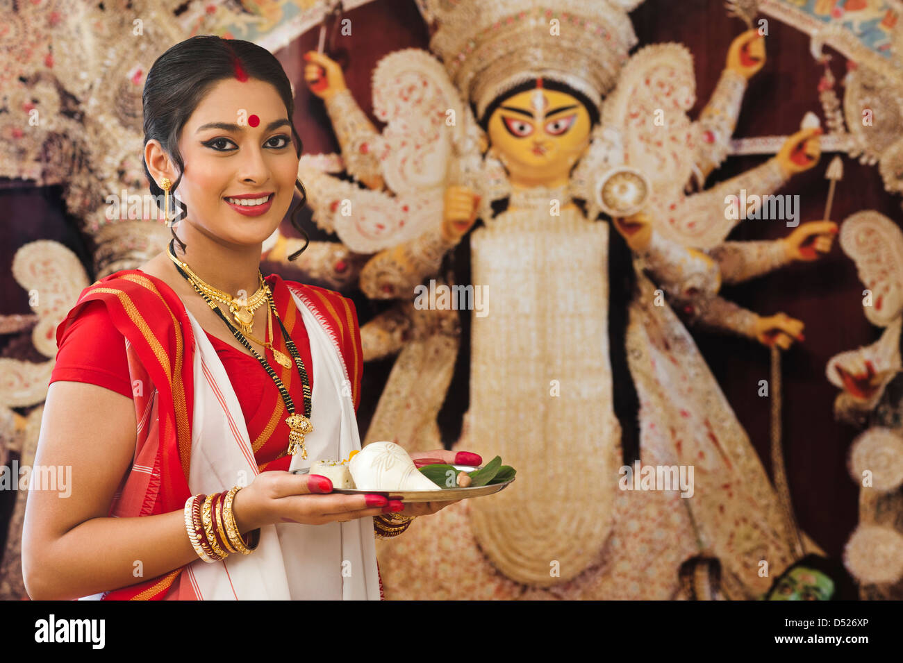 Femme tenant une puja Bengali thali à Durga Puja Banque D'Images