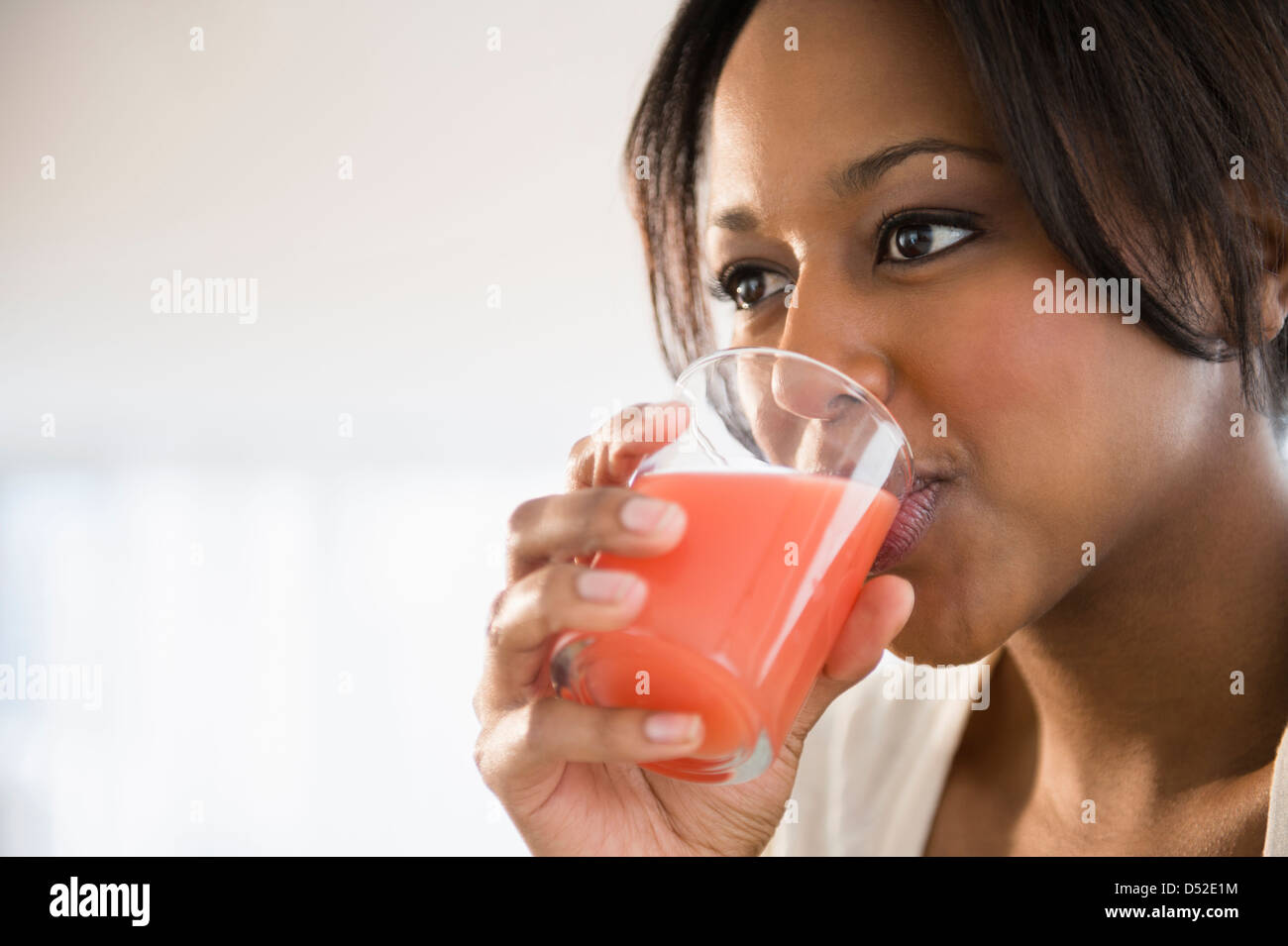 African American Woman drinking glass of juice Banque D'Images
