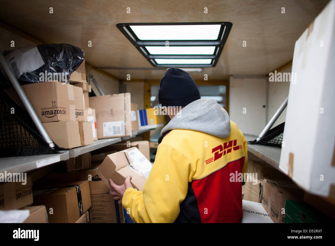 Un employé de Deutsche Post DHL met un paquet dans son courrier van lors du premier point de livraison mécanique à Bochum, Allemagne, le 20 mars 2013. C'est le deuxième réseau national qui lit les paquets automatiquement et les distribue au transporteur. Photo : Rolf Vennenbernd Banque D'Images