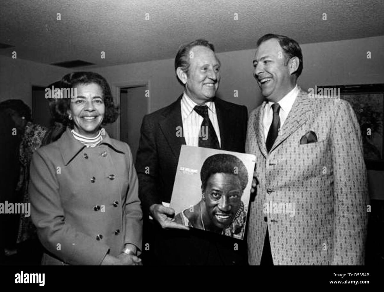 La personnalité de la télévision Art Linkletter est photographiée tenant un disque de Joe Williams alors qu'elle se tenait debout avec des personnes non identifiées à Pinecrest, en Floride. La photo capture un moment de l'histoire du divertissement au milieu du XXe siècle. Banque D'Images