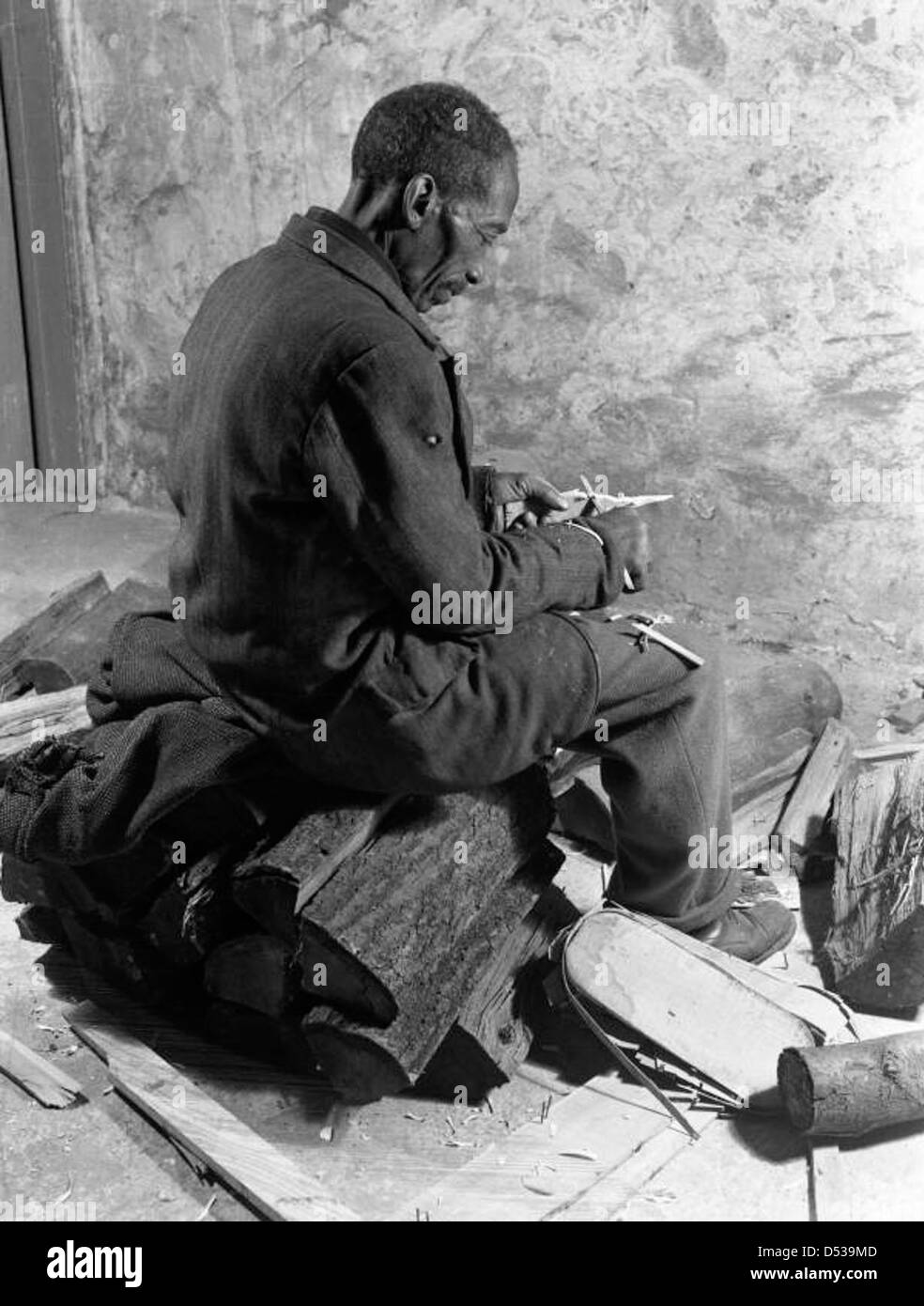 Un homme afro-américain est montré du bois blanchissant à Sarasota, en Floride. La photographie, qui fait partie de la collection Joseph Janney Steinmetz, capture un moment de travail artisanal et de menuiserie dans le comté de Sarasota. Banque D'Images