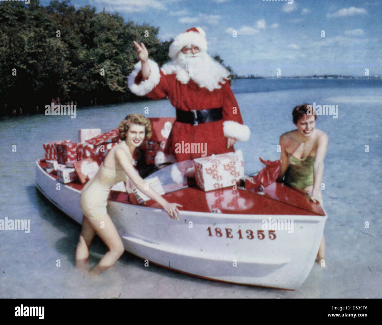 Un groupe de jeunes femmes pose avec le Père Noël pendant la saison de Noël à Sarasota, en Floride, mettant en vedette une scène festive. La photographie, prise par Joseph Janney Steinmetz, met en évidence une célébration de Noël avec des mannequins et une atmosphère de vacances dans le comté de Sarasota. Banque D'Images