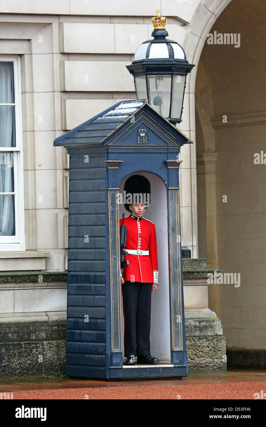 Londres, Royaume-Uni. 23 mars 2013. La Garde Royale à Buckingham Palace a ordonné de changer dans leur uniforme d'été rouge du 23 mars - n'importe quel temps et devait se tenir dans le froid et la neige comme La Relève de la garde a été annulée à Londres, en Angleterre. Le 1er Bataillon Welsh Guards ont été les premiers à effectuer la nouvelle garde et déposer les grands manteaux gris Athol. Crédit : Paul Brown / Alamy Live News Banque D'Images