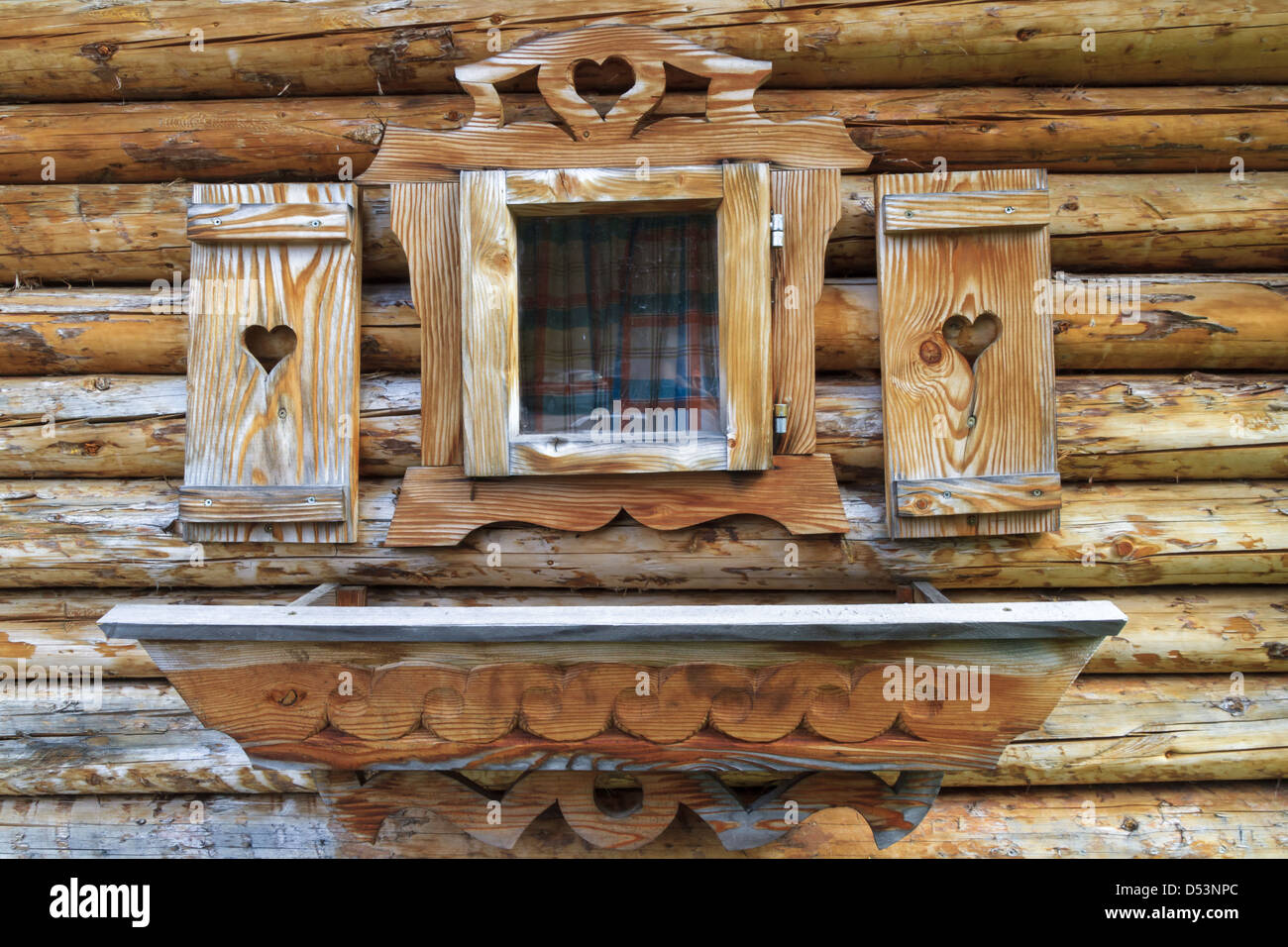 Fenêtre avec volets coeur d'un chalet en bois dans les Alpes européennes Banque D'Images