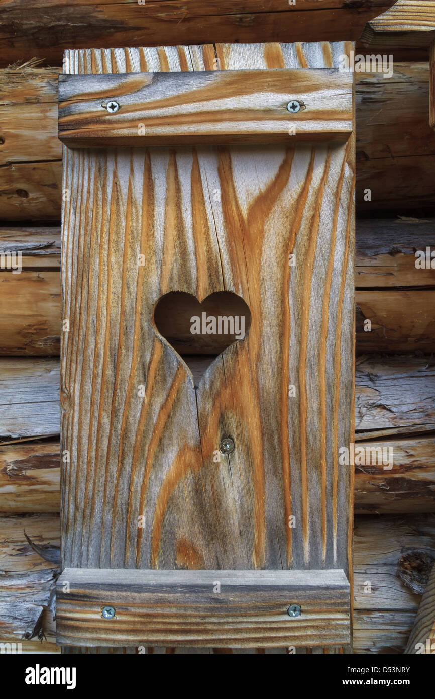 Volets avec coeur d'une cabane en bois dans les Alpes européennes Banque D'Images