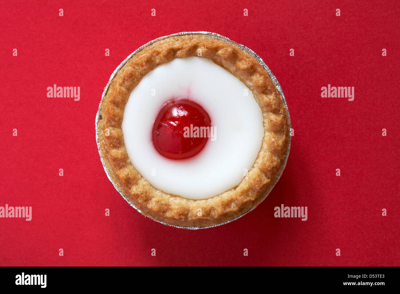 Mr Kipling cherry Bakewell tart isolé sur fond rouge Banque D'Images