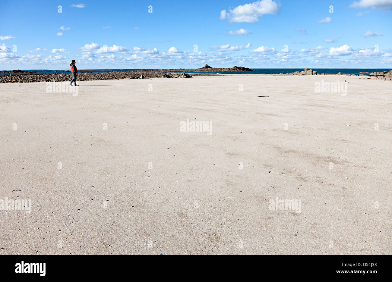 Femme marche sur une plage de sable, l'île de Jersey, Ecrehous Channel Islands, UK Banque D'Images
