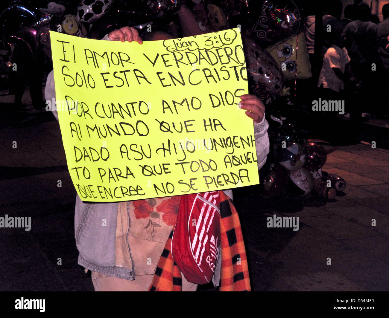 En vain l'homme contient jusqu'part par les lettres pour bien biblique en invoquant l'amour spirituel sur un païen Valentines nuit à Oaxaca Zocalo Banque D'Images