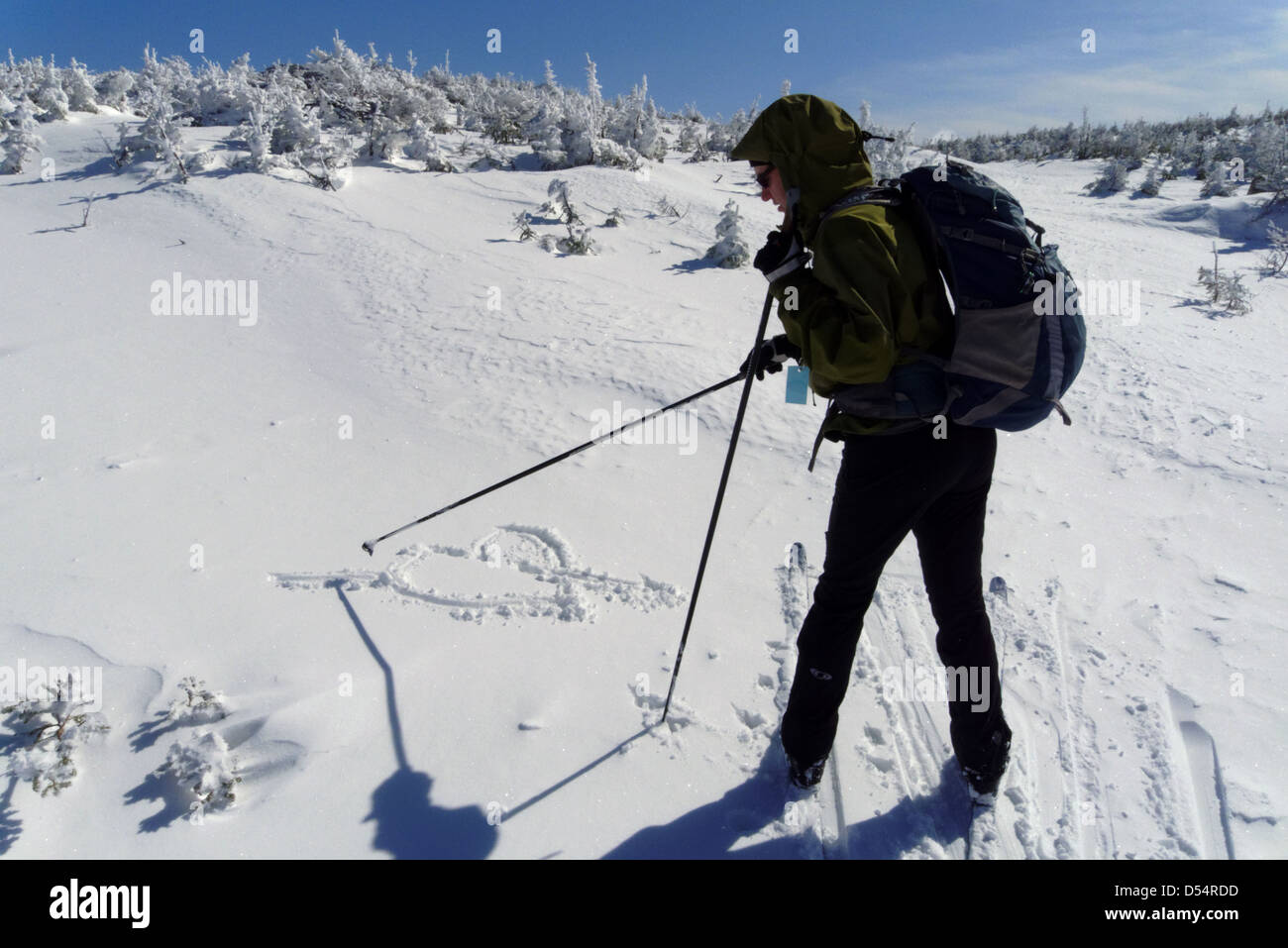 Une skieuse de dessiner un coeur d'amour dans la neige sur le plateau des monts McGerrigle, Chic Choc Montagnes, Québec Canada Banque D'Images