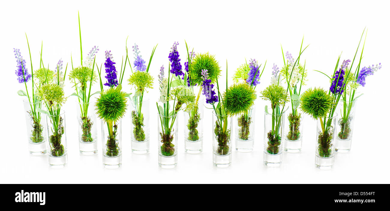 Bouquets de fleurs artificielles dans des vases de verre centre arrangement sur fond blanc. Banque D'Images