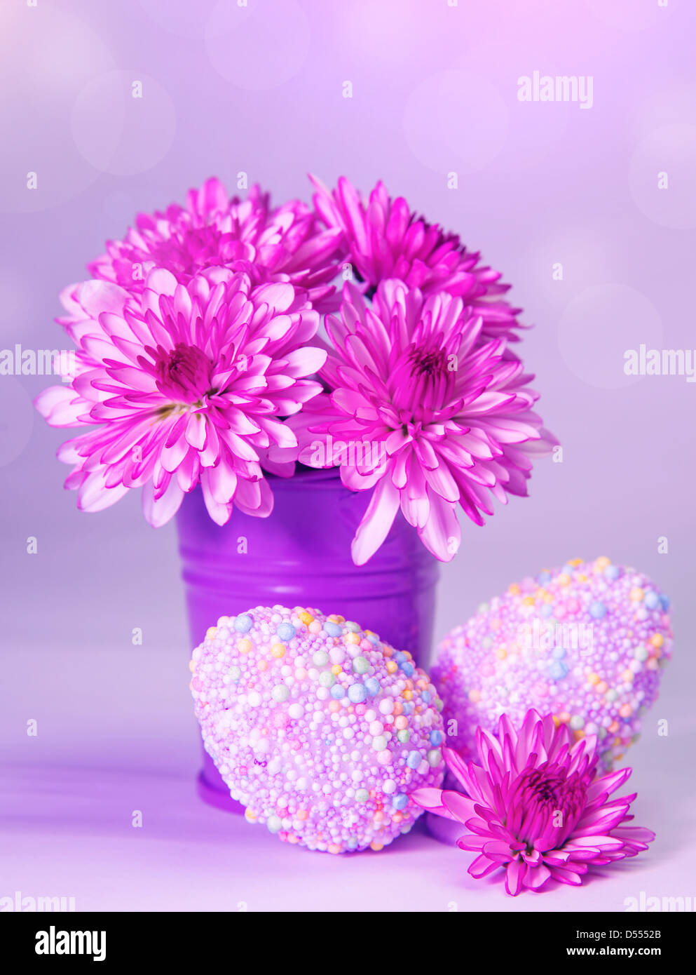 Symbole traditionnel de Pâques, les oeufs de poule avec des décorations colorées et de fleurs fraîches dans un vase isolé sur fond rose Banque D'Images