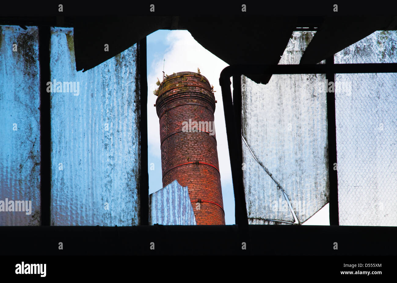 Vieille cheminée industrielle à travers le verre brisé des ruines, Bailey Mill de Delph, Bellevue, Oldham Banque D'Images