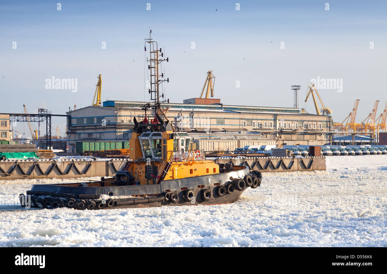 Petit remorqueur bateau va sur le canal de glace dans le port de Saint-Pétersbourg port marchand Banque D'Images
