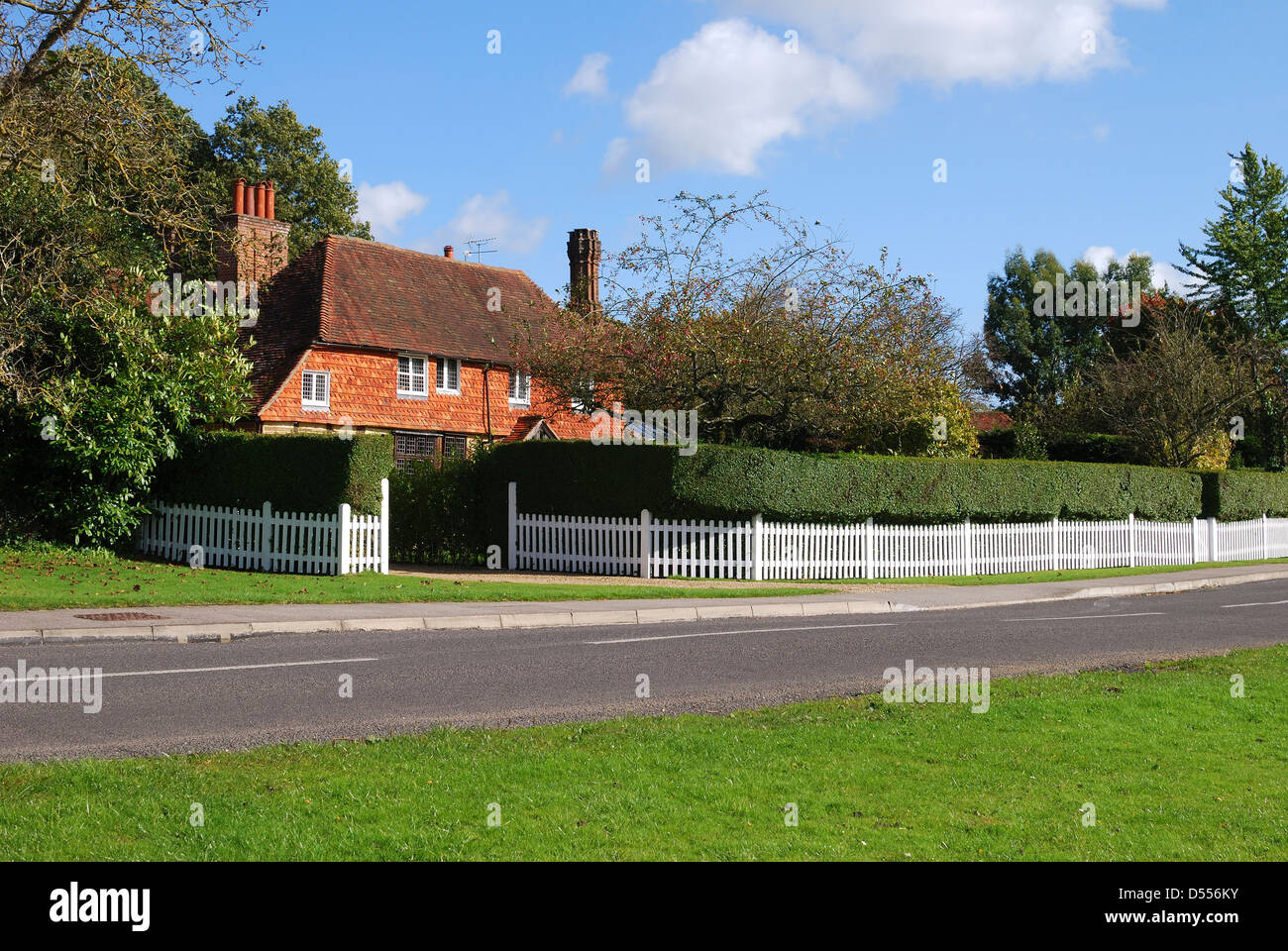 Sol carrelé et brique cottage derrière picket fence à Chiddingfold. Surrey. L'Angleterre Banque D'Images
