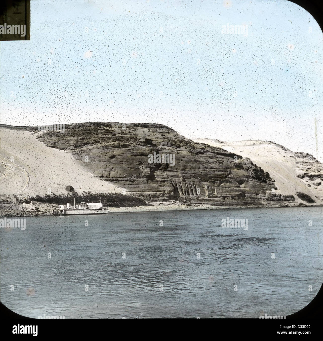 Une photographie teintée à la main des temples d'Abou Simbel en Égypte, représentant les statues massives de Ramsès le Grand. Ces temples taillés dans la roche, situés près du Nil, sont un site du patrimoine mondial de l'UNESCO et sont célèbres pour leur taille monumentale et leur importance historique. Banque D'Images