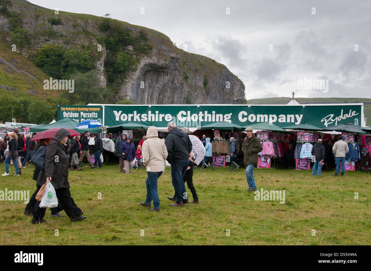 Grande foule de gens à marcher dans la pluie showground campagne par des pieds & expose au salon agricole occupé - Kilnsey, Yorkshire, Angleterre, Royaume-Uni Banque D'Images