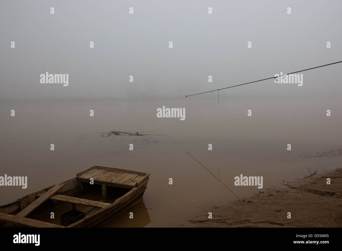 Un matin brumeux sur la rivière Beas avec bateau en bois et corde de bac sur l'eau dans le Pendjab en Inde Banque D'Images