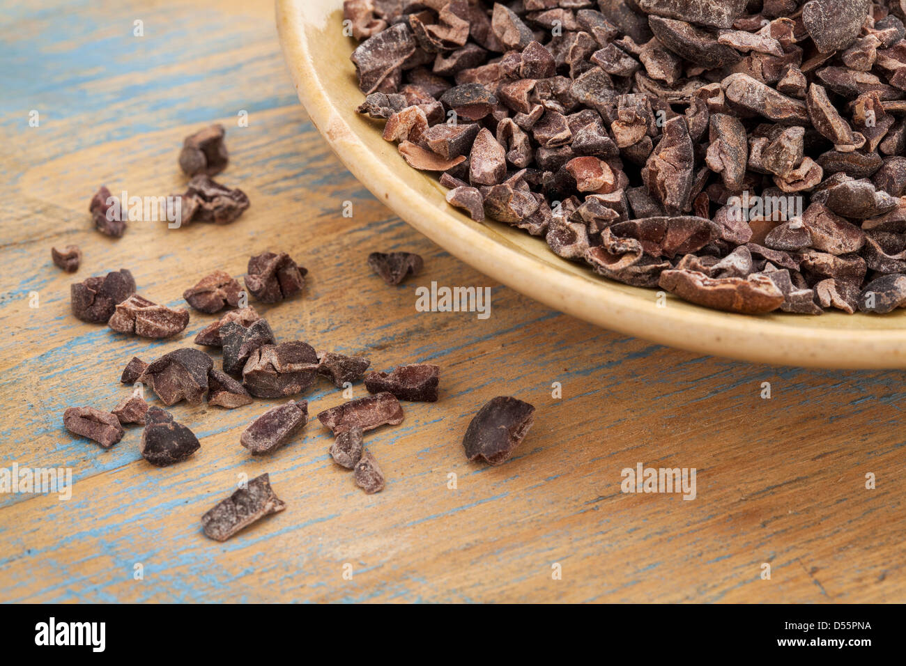 Matières cacao nibs dans un petit bol en céramique contre grunge background Banque D'Images