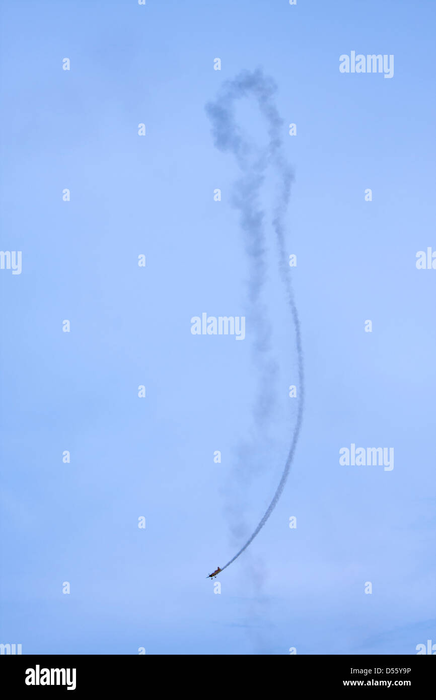 Avion acrobatique faisant des acrobaties avec la fumée sur le ciel Banque D'Images