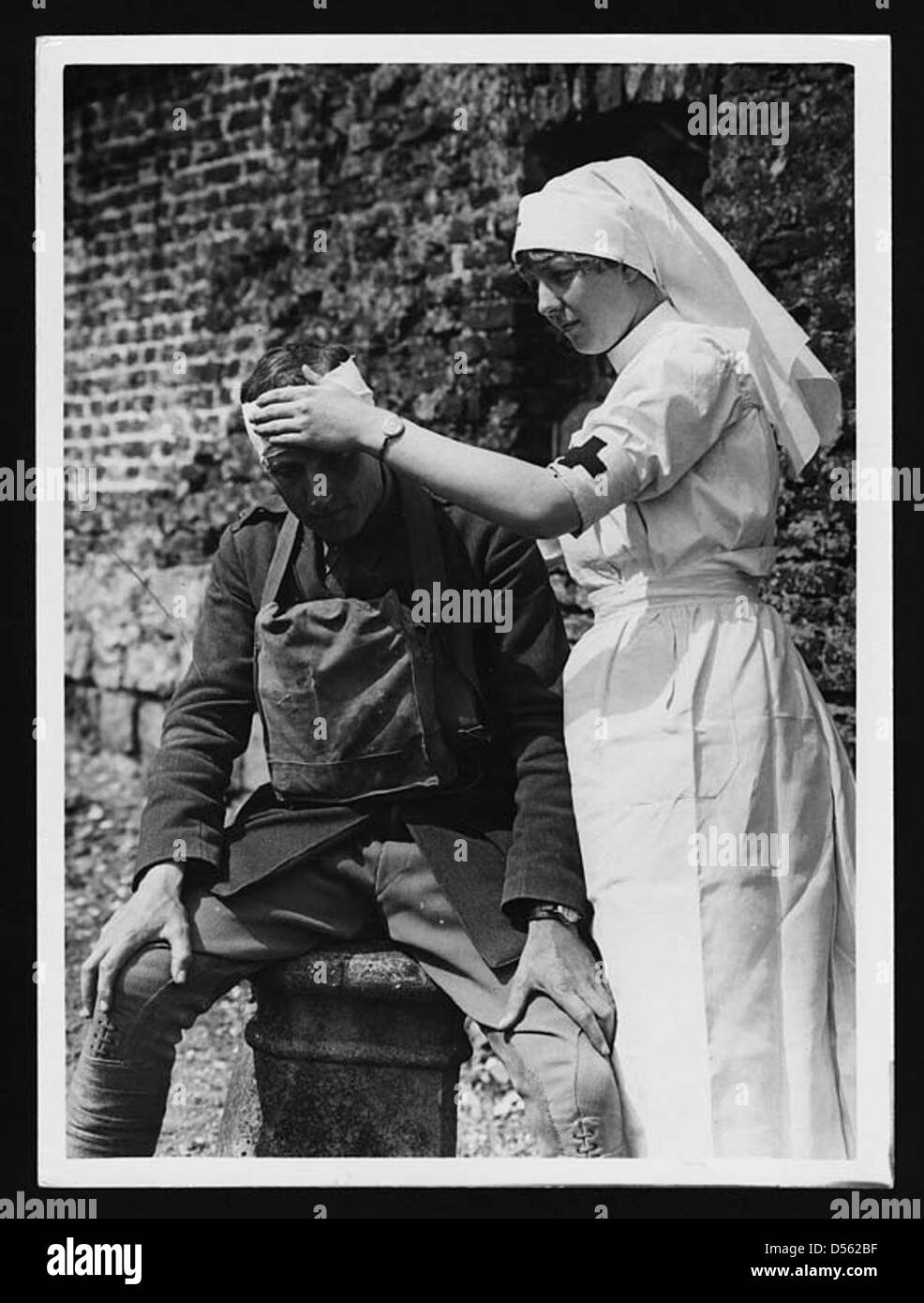 Un officier est suivi par du personnel médical après un accident de voiture pendant la première Guerre mondiale. Cette image reflète les divers défis auxquels sont confrontés les militaires, même en dehors du combat, et les soins médicaux dispensés en temps de guerre. Banque D'Images