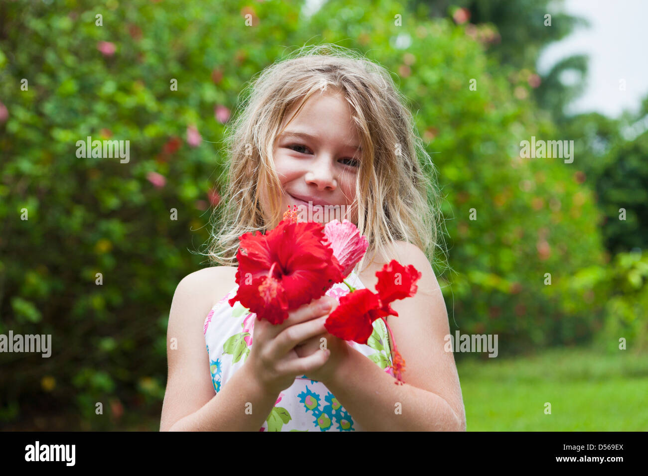 Caucasian girl holding red flowers Banque D'Images