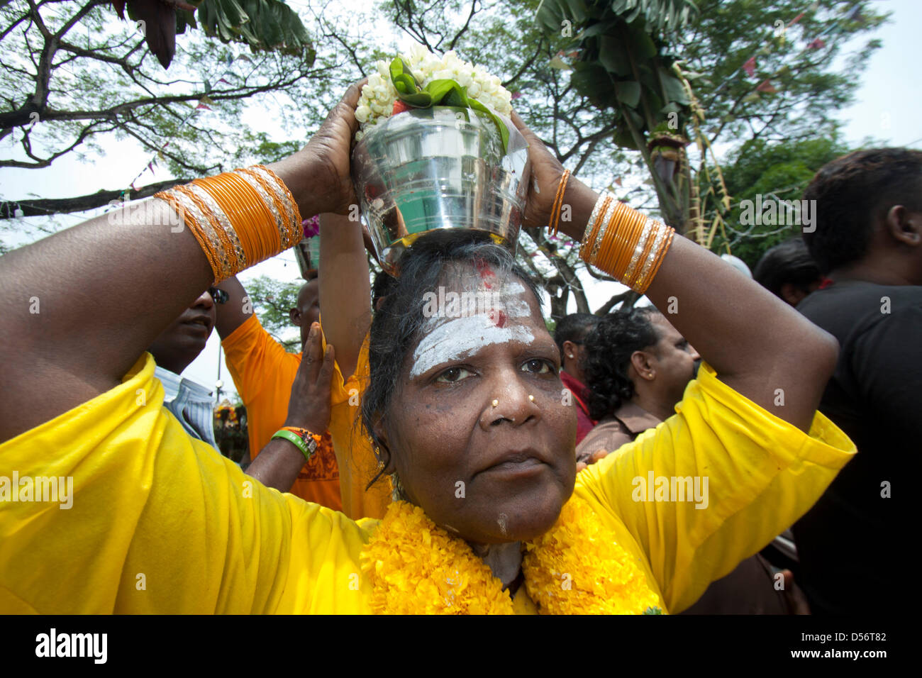 Singapour. 26 mars 2013. Une femme dévote au festival de Thaipusam porte un pot de lait sur sa tête. Le festival de Thaipusam commémore la victoire du bien sur le mal et est célébré par les dévots hindous qui portent le fardeau physique connu comme Kavadi avec porteurs et prendre leurs joues piercing et des langues. Credit : amer ghazzal / Alamy Live News Banque D'Images