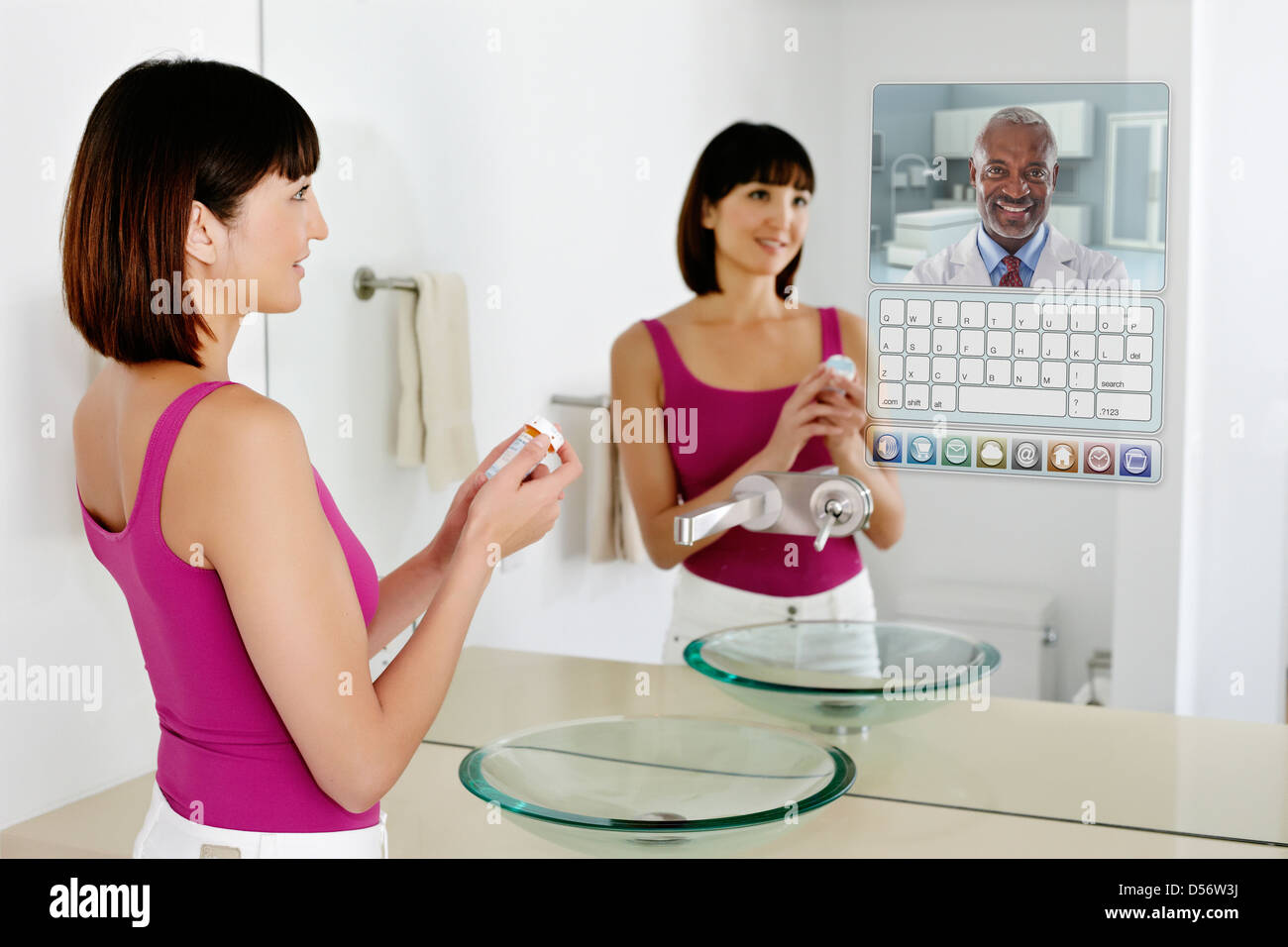 Mixed Race woman using computer in mirror Banque D'Images