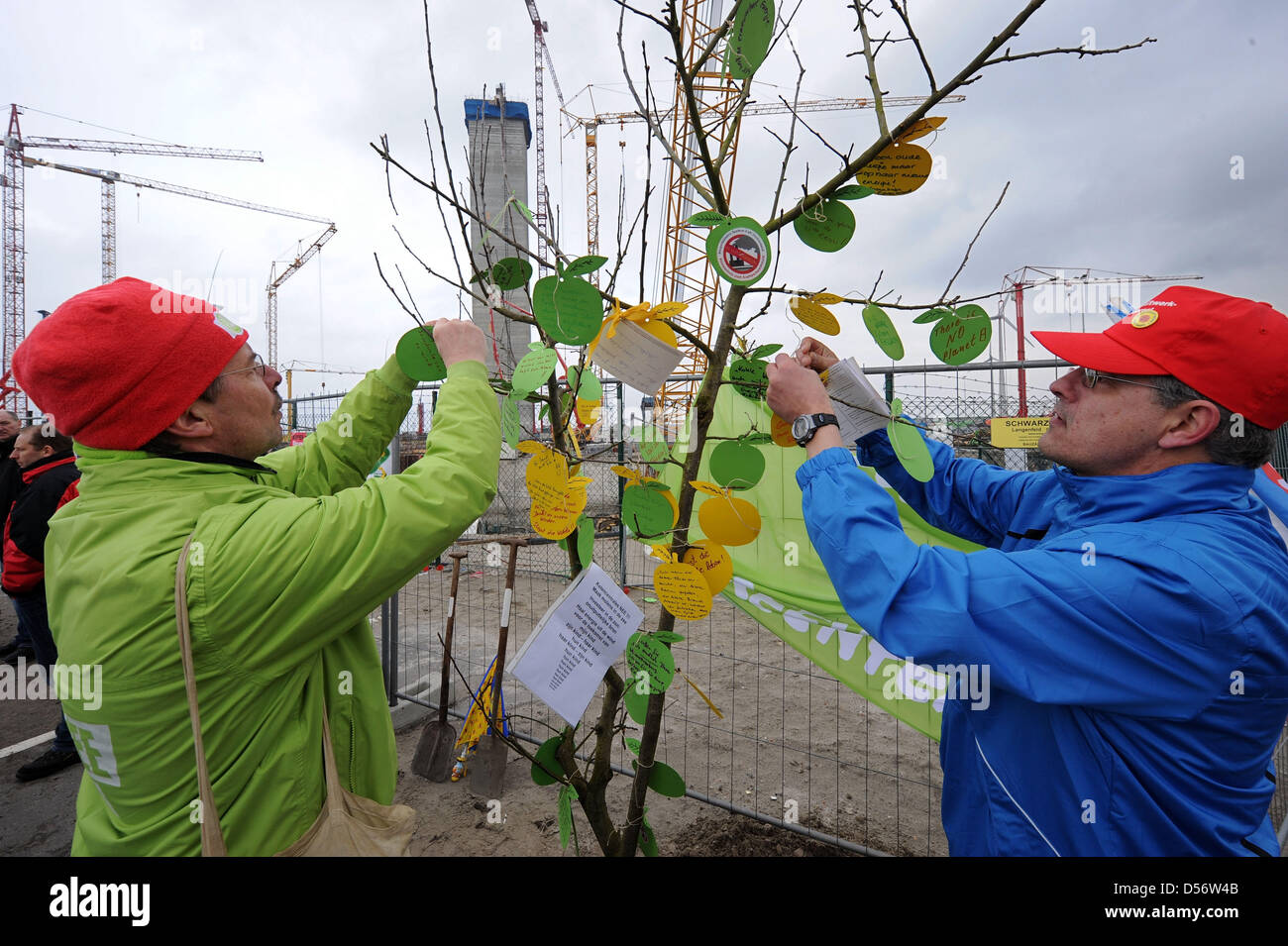 Les environnementalistes attacher leurs souhaits pour l'environnement à un arbre fraîchement planté près de l'apple d'un site de construction de fournisseur d'énergie RWE pour une centrale électrique au charbon à Eemshaven, aux Pays-Bas, le 27 mars 2010. Environ 100 Allemand et Néerlandais écologiste a participé à l'événement de protestation ; l'initiative a eu lieu dans le cadre d'une manifestation contre la construction de centrales au charbon Banque D'Images