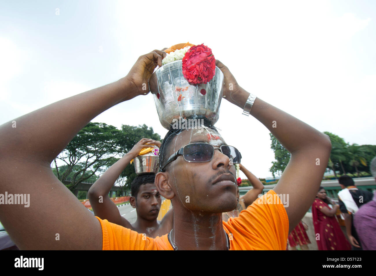 Singapour. 26 mars 2013. Les dévots Hindous portent sur leurs têtes des pots de lait comme offrandes au festival de Thaipusam. Le festival de Thaipusam commémore la victoire du bien sur le mal et est célébré par les dévots hindous qui portent le fardeau physique connu comme Kavadi avec porteurs et prendre pour percer leurs joues et langues Crédit : Amer Ghazzal/Alamy Live News Banque D'Images